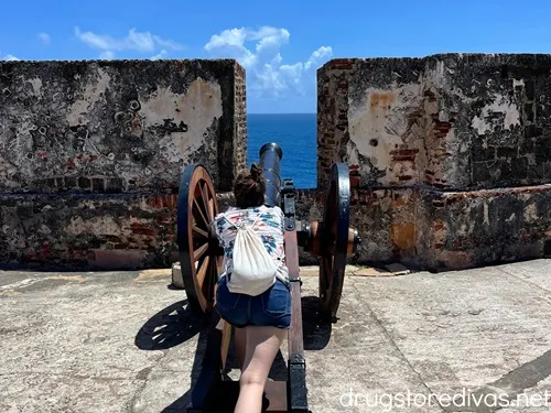 A woman standing like she's about to shoot a cannon at Castillo San Felipe del Morro in San Juan, Puerto Rico.