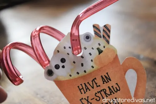 A red straw going through a paper cup that says "Have An Ex-Straw Special Halloween".