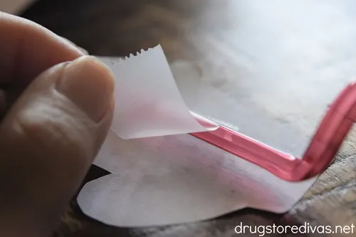 Tape securing a red straw to a piece of paper.