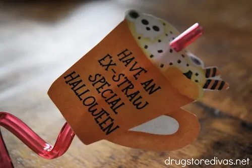 A red straw going through a paper cup that says "Have An Ex-Straw Special Halloween".