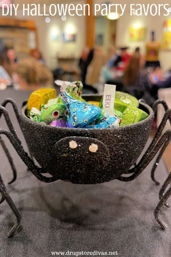 A spider Halloween decoration filled with Hershey's Kisses and the words "DIY Halloween Party Favors" digitally written on top.