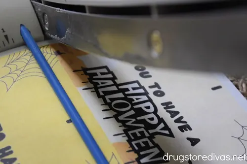 A paper trimmer cutting Halloween cards.