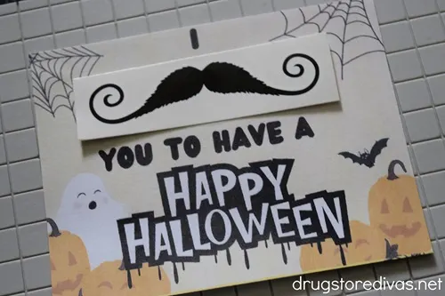 A Halloween card that says "I mustache you to have a Happy Halloween" where the mustache is a temporary tattoo.