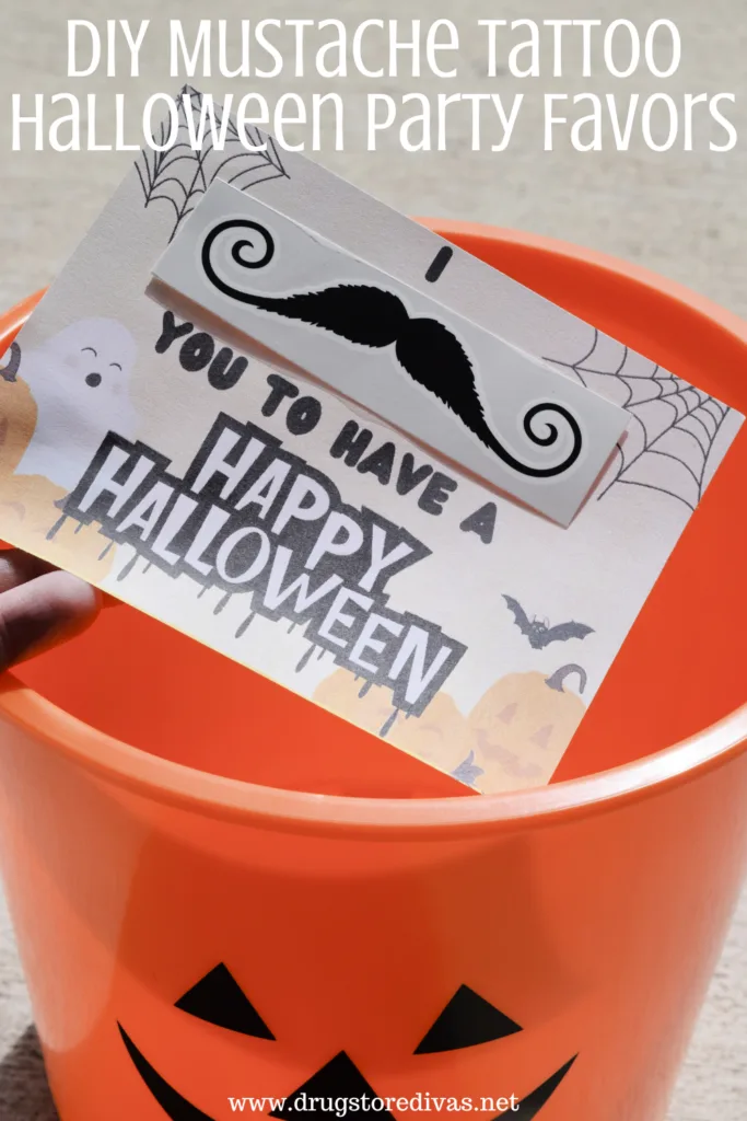 A DIY Halloween card going into an orange pumpkin bucket with the words "DIY Mustache Tattoo Halloween Party Favors" digitally written on top.