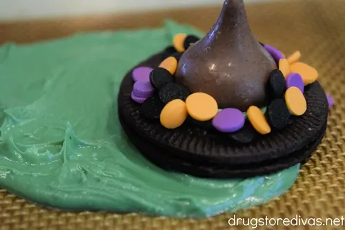 An Oreo cookie that looks like a hat in a circle of melted green chocolate.