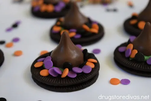 A bunch of Oreo cookies decorated to look like witches hat on a white tray.