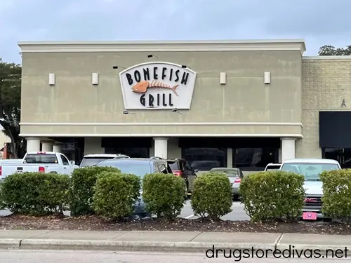 The outside of a Bonefish Grill restaurant and part of its parking lot.