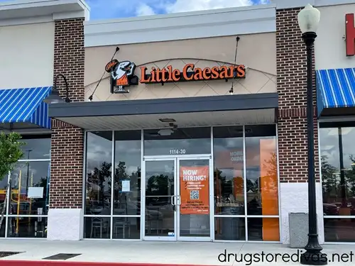 The outside of a Little Caesar's restaurant in a strip mall.