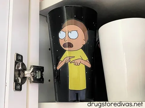 A black mug with Morty from Rick & Morty on it next to a white mug.