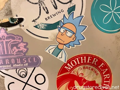 Vinyl stickers on a wall including one that looks like Rick from Rick and Morty in the center.