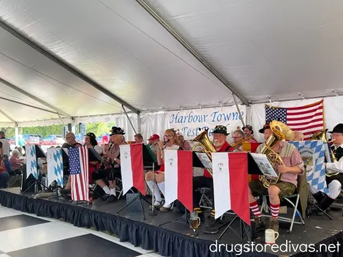 A polka band on a stage with flags in front of them.