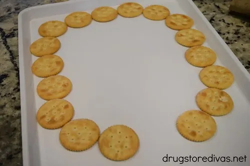 A semi circle of Ritz crackers on a white tray.