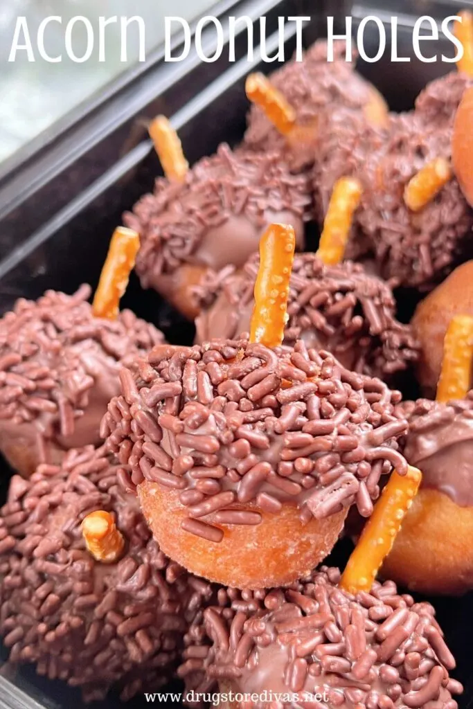 Donut holes that look like acorns in a black container with the words "Acorn Donut Holes" digitally written on top.