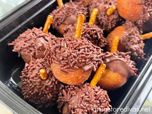 Donut holes decorated to look like acorns in a black container.