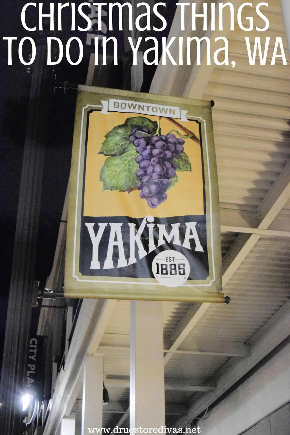 A sign with grapes and hops on it that says Yakima 1895 hanging off a building at night with the words 