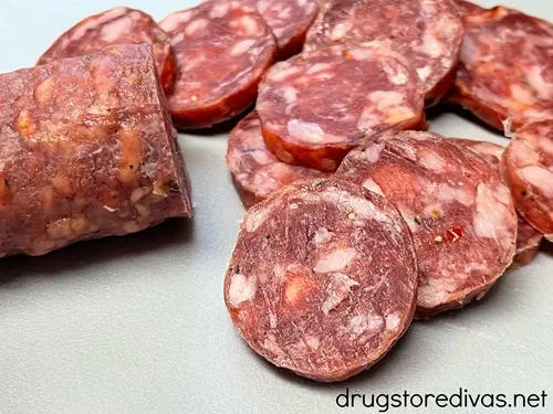Hard salami slices on a gray cutting board.