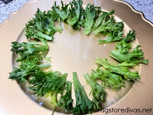 Green lettuce arranged in a circle around a gold charger plate.
