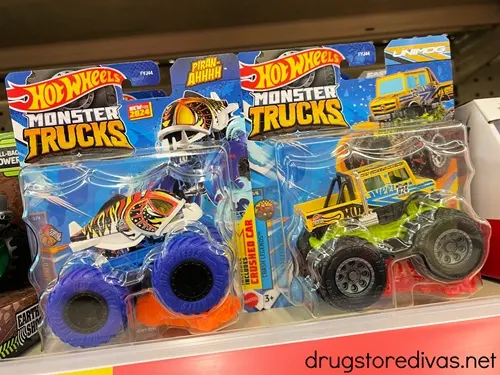 Two Hot Wheels Monster Trucks in their packages on a shelf.