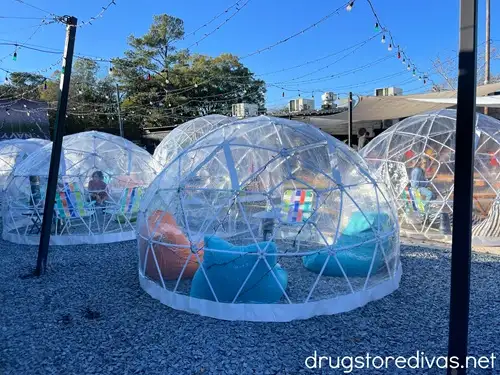 Three plastic igloos with chairs and people inside at The Rift in Wilmington, NC.