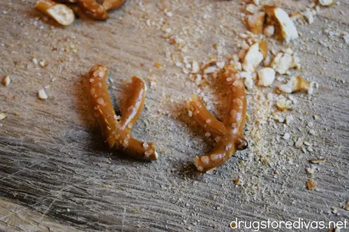 A mini pretzel twist cut in half with pretzel dust around the pieces.