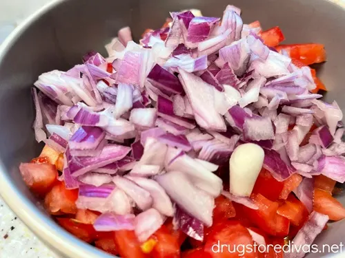 Diced tomatoes and red onion in a bowl.