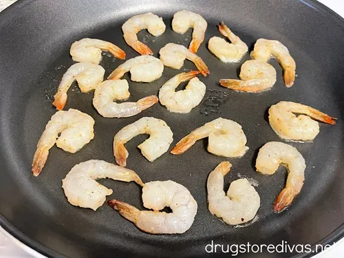 Raw shrimp in a skillet.