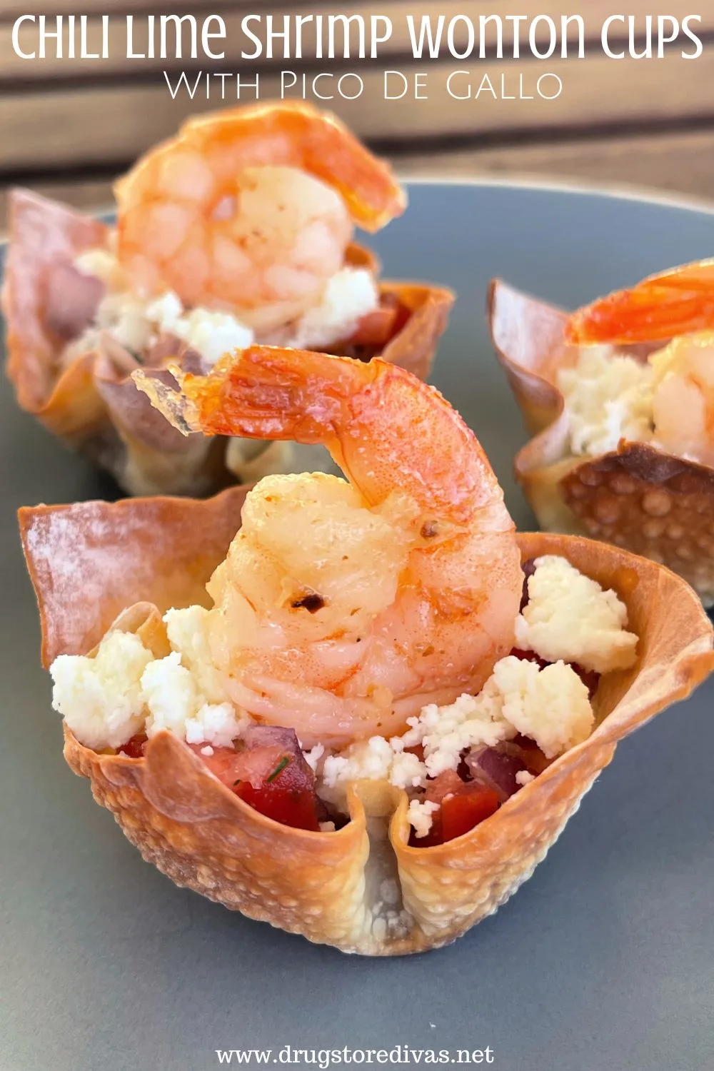 Three wonton cups filled with pico de gallo and crumbled cheese with a shrimp with its tail up on top and the words 