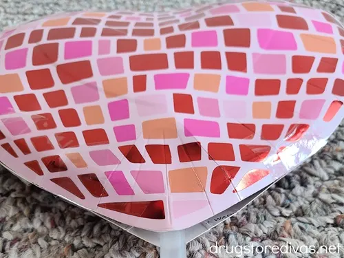 A heart-shaped disco ball-looking plate with a straw at the bottom.