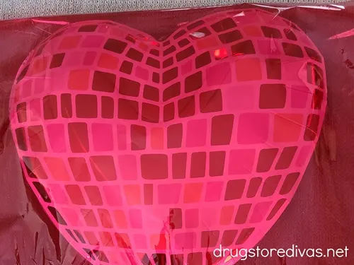 A heart-shaped disco ball-looking plate covered in red cellophane.