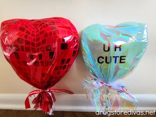 Two DIY Jumbo Lollipop Treat Holders next to each other with a red one one the left and a right one that says UR CUTE on the right.