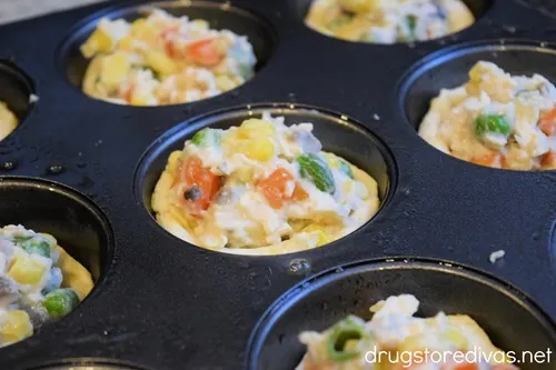 Unbaked mini chicken pot pies in a muffin tin.