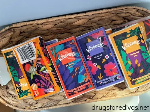 A bunch of travel sized tissue packs in a wicker basket.