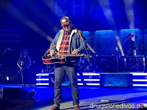 A man playing a slide guitar standing on stage at Live Oak Bank Pavilion in Wilmington, NC.