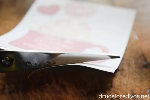 Scissors cutting a piece of paper.