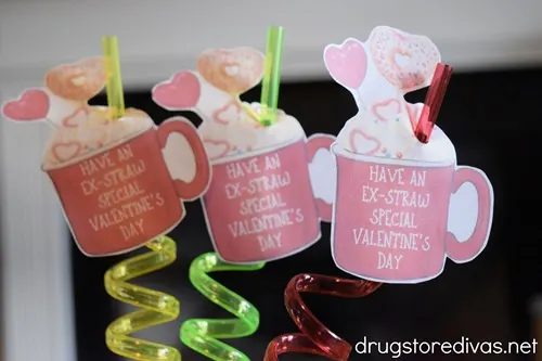 Three crazy straws, in yellow, green, and red, with tags that are an image of a red cup on them.