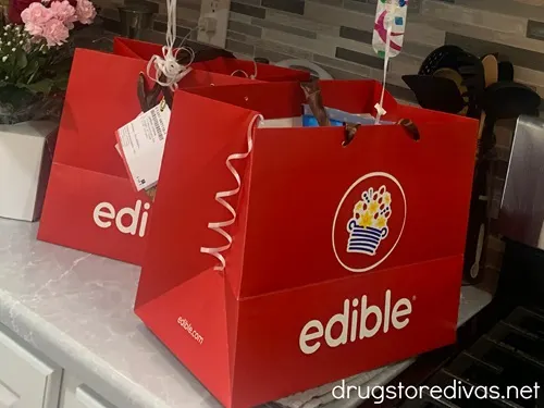Two Edible Arrangement bags on a kitchen counter.