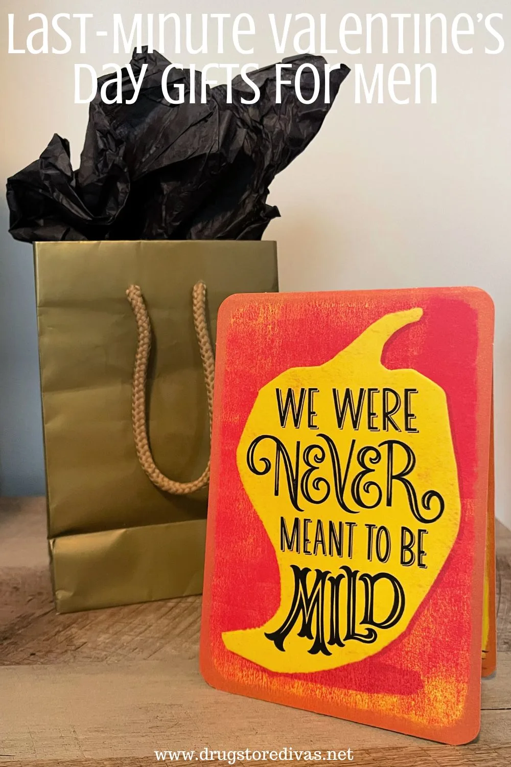 A gold gift bag with black tissue paper coming out the top behind a red card with a yellow chili pepper on it and the words 