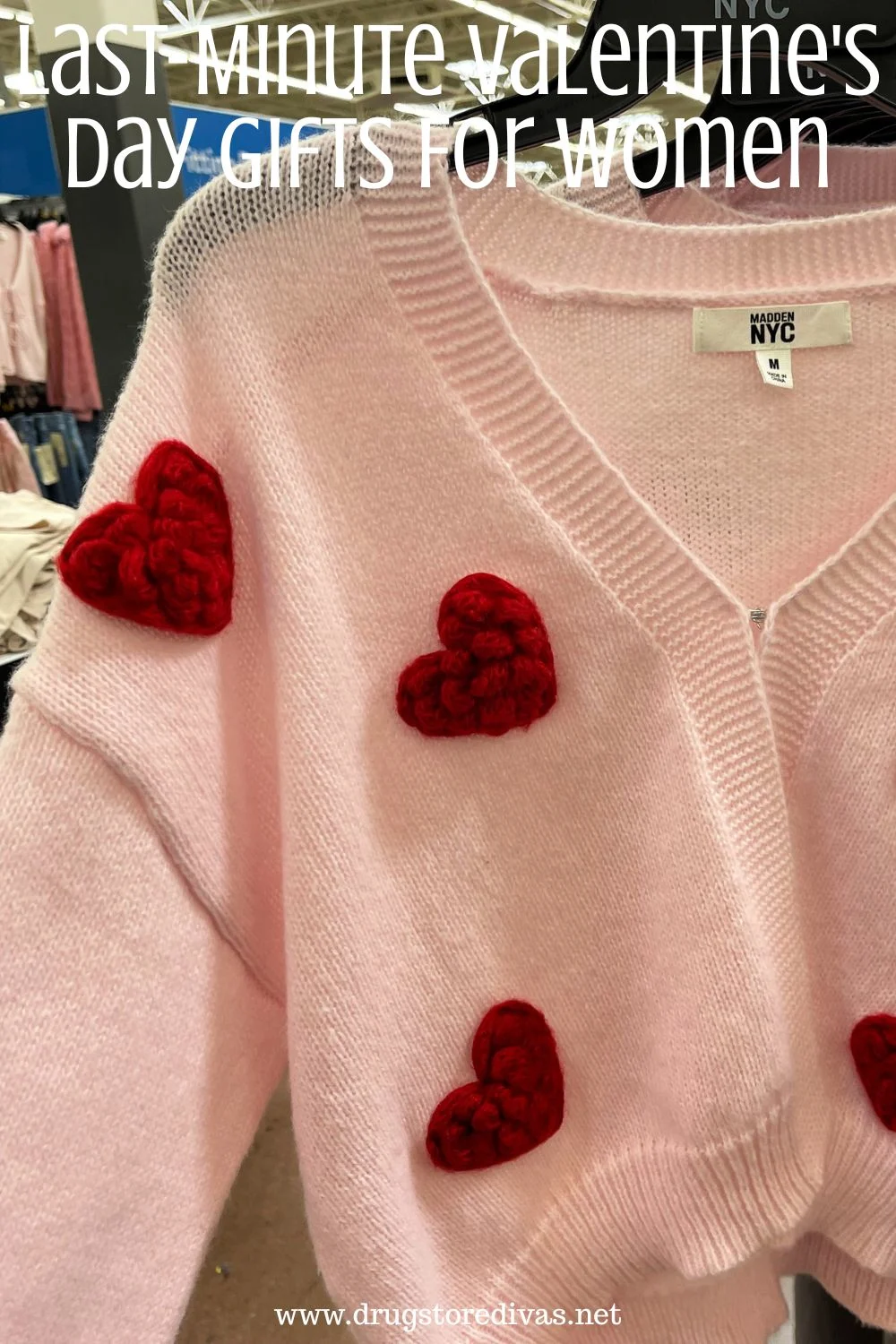 A pink sweater with red hearts on it and the words 