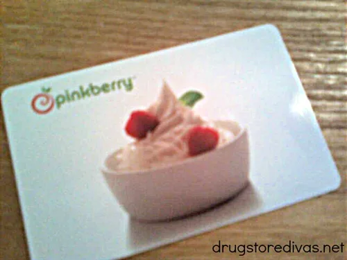 A Pinkberry gift card on a wooden table.