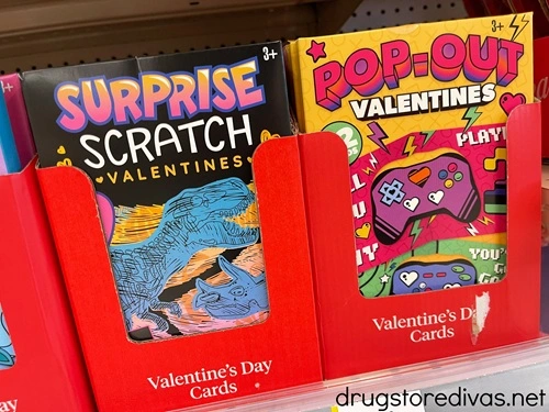 Two packs of Valentine's Day cards on a shelf in a store.