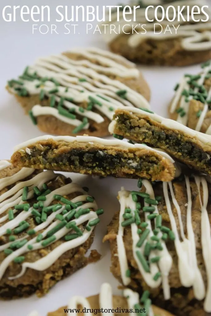 Brown, round cookies with white drizzle and green sprinkles on a white tray with one in the center cut in half with a green center showing to the front of the frame and the words "Green Sunbutter Cookies for St. Patrick's Day" digitally written on top.