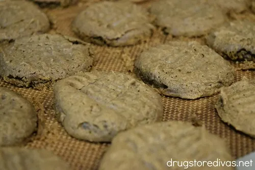 A tray of brown, cooked cookies with crisscross marks on them.