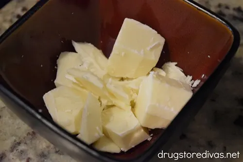 Pieces of vanilla almond bark in a maroon bowl.