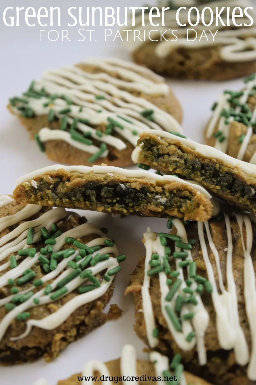 Brown, round cookies with white drizzle and green sprinkles on a white tray with one in the center cut in half with a green center showing to the front of the frame and the words 