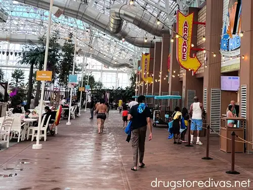 People walking around and a sign pointing to an arcade at Island Waterpark at Showboat Hotel.