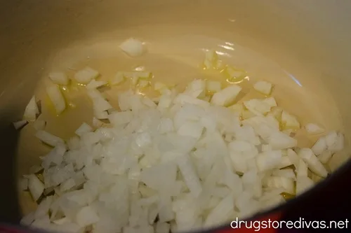 Diced onions in a red Dutch oven.