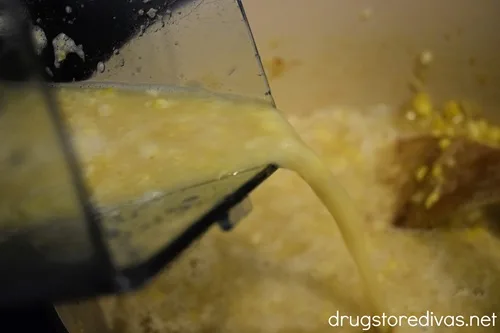 Liquid being poured from a blender into a Dutch oven.