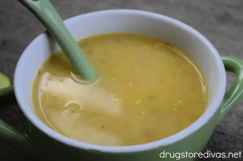 Mexican Street Corn Soup in a green bowl with a green spoon in it.