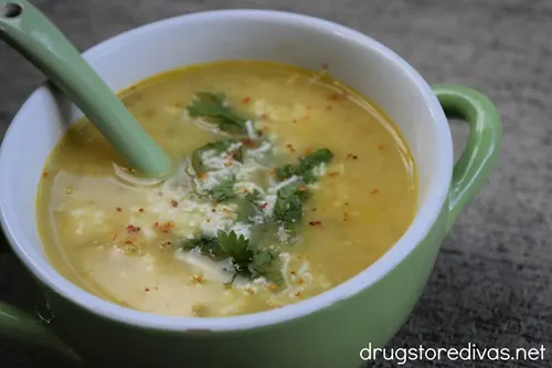 A bowl of Mexican Street Corn Soup with cilantro and shredded cheese on top.