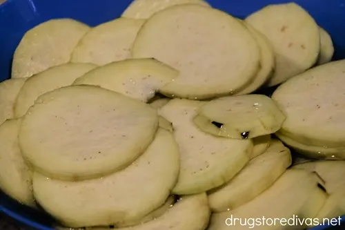 Eggplant rounds in a blue bowl.